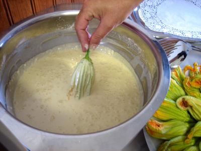 Plonger les fleurs de courgettes dans la pâte à frire